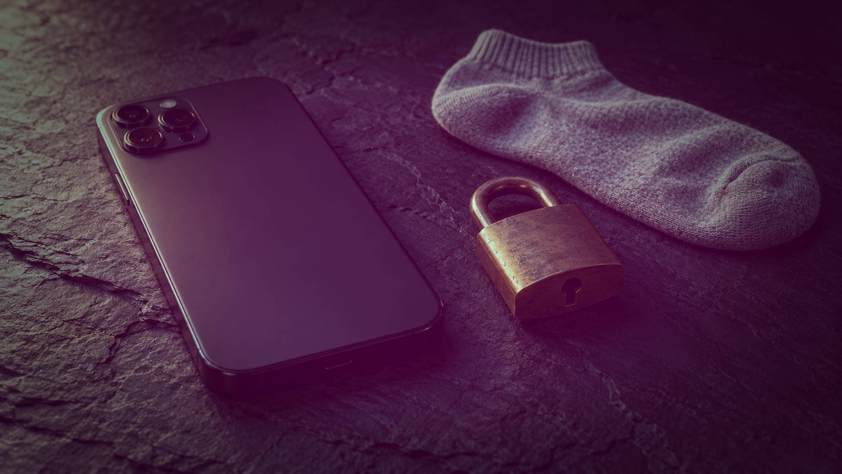 Protecting Your Privacy When Selling Feet Pics Face-down smartphone beside a brass padlock and grey ankle sock on dark slate, softly lit from the left.